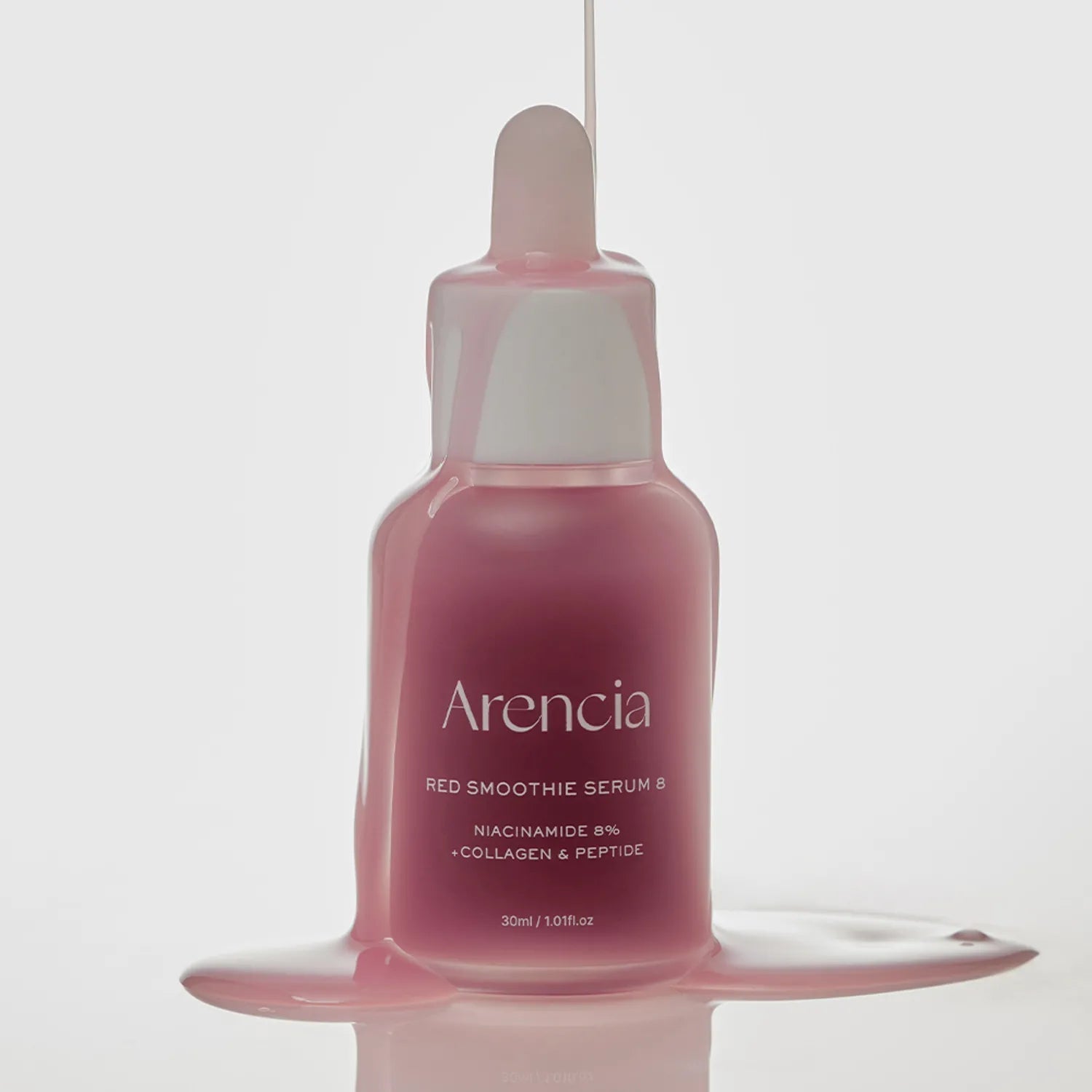 Pink serum bottle with dropper labeled 'Arenicia' on a light gray background