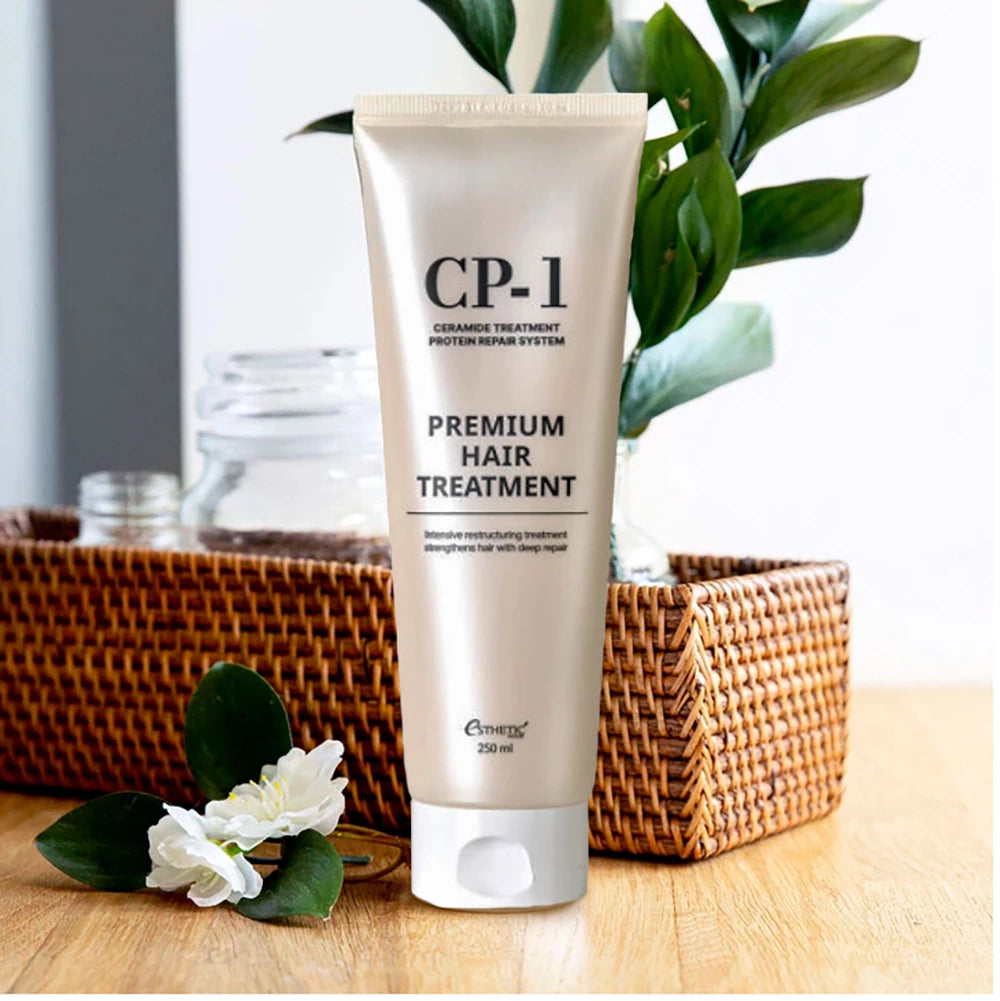 Tube of CP-1 Premium Hair Treatment on a wooden surface with a plant in the background