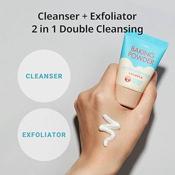 Hand holding a tube of baking powder cleanser with product application on skin, labeled as cleanser and exfoliator. Iceland