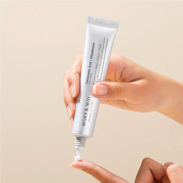 Hand holding a skincare tube labeled 'Mary & May' against a beige background. Iceland