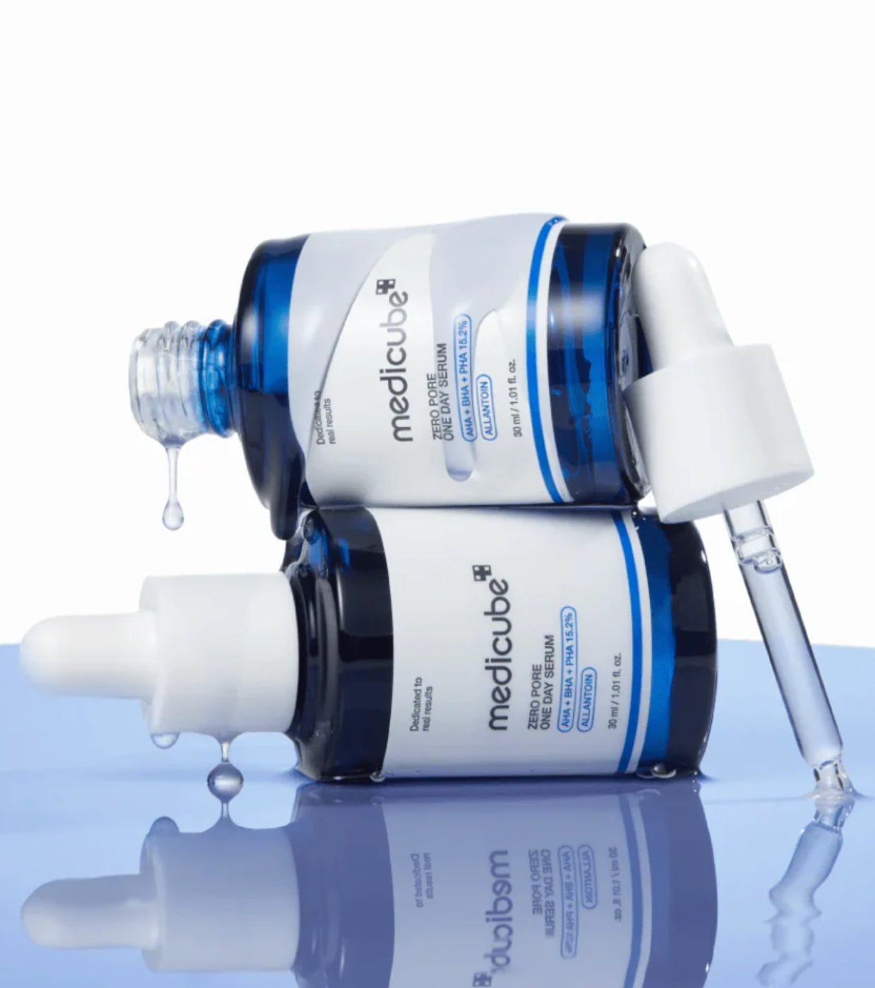 Two bottles of Medicube skincare products on a reflective surface with a white background