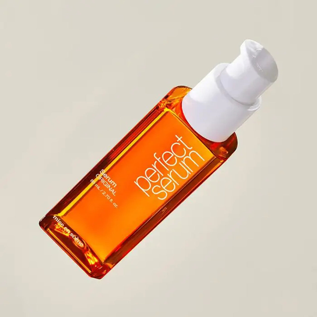 Orange serum bottle with white pump on a beige background