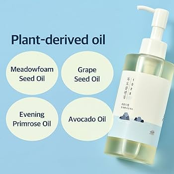 Bottle of plant-derived oil with labels for meadowfoam seed oil, grape seed oil, evening primrose oil, and avocado oil on a blue background.