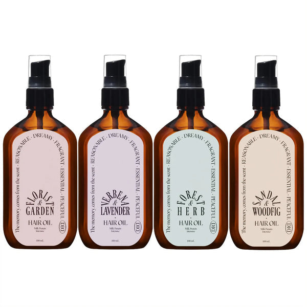 Four bottles of hair oil with labels on a white background